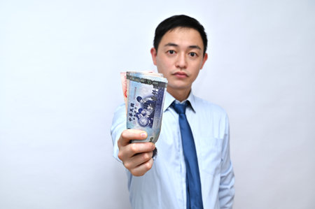 Asian male office worker holding New Taiwan dollars in red packets, White background.の写真素材