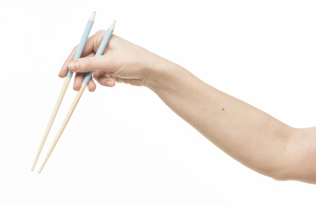 Female hand holding chopsticks, isolated on the whiteの写真素材