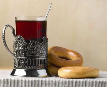 Tea in glass and bread-ring on tableの写真素材