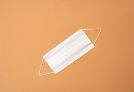 White medical mask on orange background