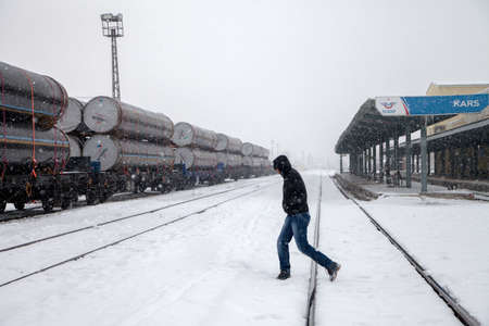 Kars,Turkey - 01242016: Unknown three young people walking in the train station on a cold winter...