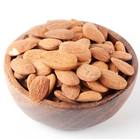 Close-up almonds in the bowl. on white backgroundの写真素材