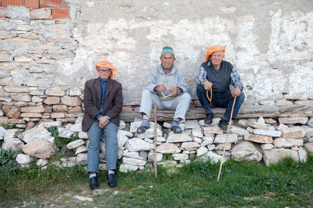 Manisa,Turkey - 04-20-2016:A group of old men resting on the wallのeditorial素材