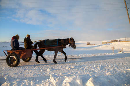 Kars/Turkey - 01/27/2106: Unknown people are traviling by horse carrige on snowy road.のeditorial素材