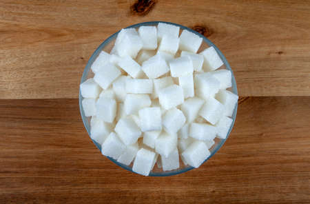 Top view of white sugar cubes in glass bowl,wooden backgroundの写真素材