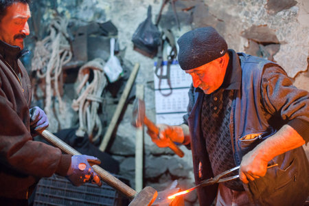 Kars,Turkey - 01-23-2016:Two old blacksmith working metal with hammer on the anvil in the forge,Kars provinceのeditorial素材