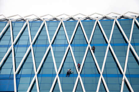 Nursultan,Kazakhstan - 04-28-2017: The view of the building on the Independence Square. Workers are cleaning the facade of a building.のeditorial素材