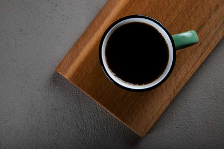 Green a cup of coffee on concrete background,top view