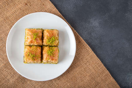 Pistachio baklava on a white plate.A plate baklava on bright background