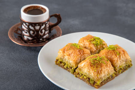 Traditional pistachio baklava with Turkish coffee.A plate of baklava on dark backgroundの写真素材