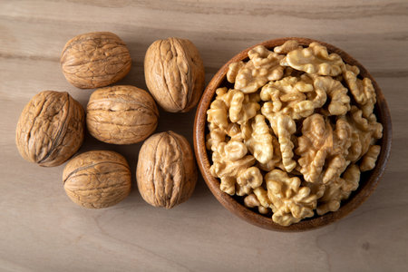 A bowl of peeled walnuts and a group of shelled walnutsの写真素材