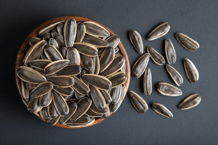 Black sunflower seeds in a bowl on dark backgroundの写真素材