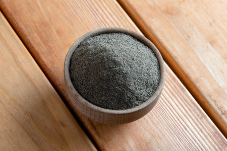 Powder black pepper on wooden background, top viewの写真素材
