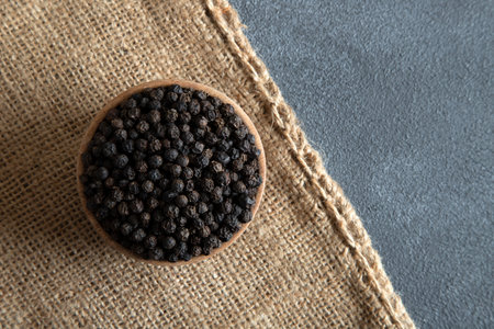 Powder black pepper on burlap sack,top view