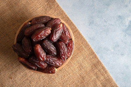 Date fruits in wooden bowl,top view
