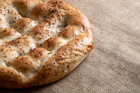 Turkish pide bread with sesame seeds on a burlap background