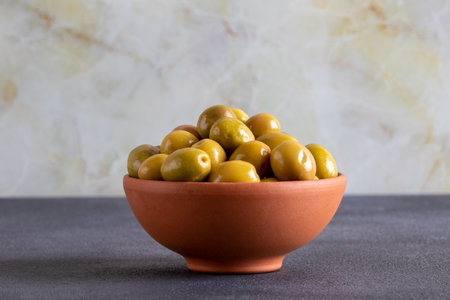 Bowl full of green olives on black backgroundの写真素材