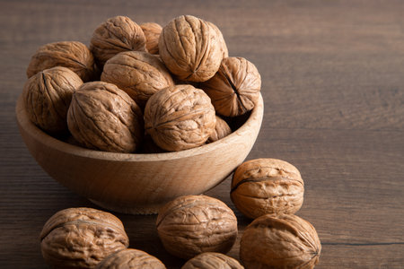 Walnuts in a wooden bowl on a wooden background. close-up.