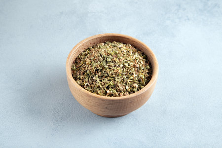 A bowl full of dried and ground natural mountain thyme on light background.の写真素材