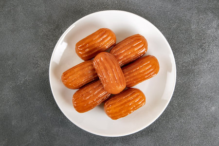 Traditional Turkish dessert tulumba on a plate. Tulumba dessert, fried in oil and soaked in syrupの写真素材