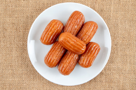 Traditional Turkish dessert tulumba on a plate. Tulumba dessert, fried in oil and soaked in syrupの写真素材