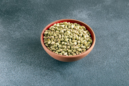 A bowlful of naturally dried thyme seeds on gray background