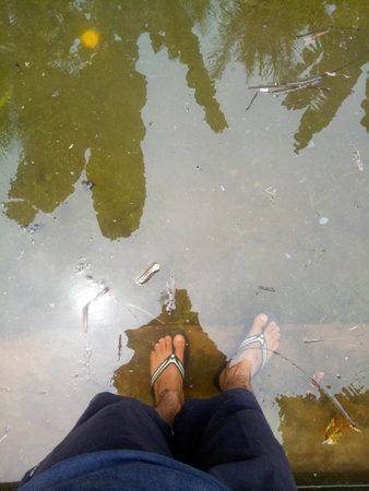 photo of a man's feet soaking in water.の写真素材