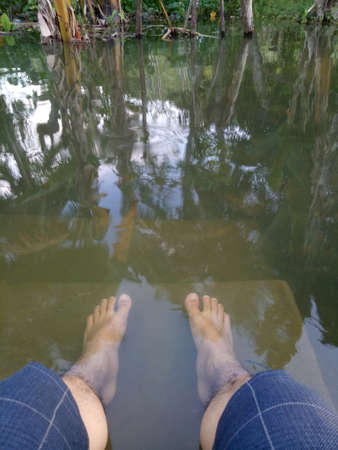 photo of a man's feet soaking in water.の写真素材