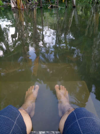 photo of a man's feet soaking in water.の写真素材