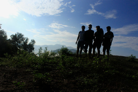 Gorontalo, 16 May 2021 - silhouette of a group of men on a mountain top against a clear sky backgroundのeditorial素材