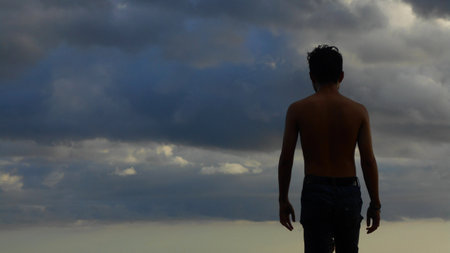 back view of a shirtless man against a foggy sky backgroundの写真素材