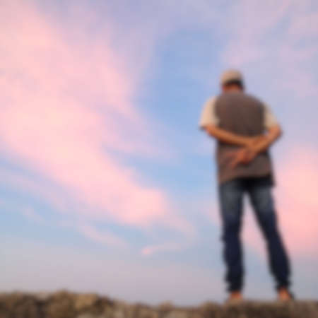 defocused on a man's back view against an orange sky background.の写真素材