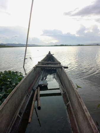 a traditional fishing boat anchored on the shore of Limboto Lake, Gorontalo.の写真素材
