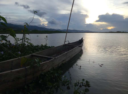 a traditional fishing boat anchored on the shore of Limboto Lake, Gorontalo.の写真素材