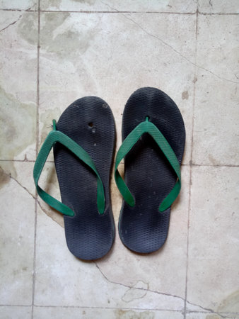 old grungy torn slippers on dirty floorの写真素材