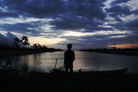silhouette of a person on the lakeの写真素材