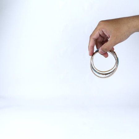 hand holding gold bracelet jewelry on white backgroundの写真素材