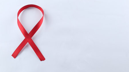 Red Support Ribbon isolated on white background. World aids day and national HIV/AIDS and aging awareness month with red ribbon. copyspace areaの写真素材