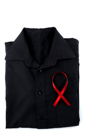 Red ribbon on a black shirt on a white background. Modern treatment and healthcare. AIDS awareness conceptの写真素材