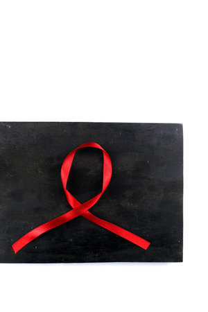 red aids ribbon on old wood background