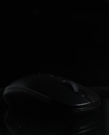 Black computer mouse on black background