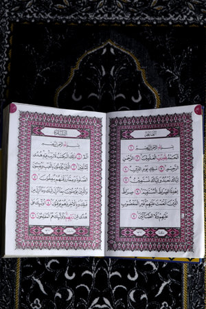 Al-Quran which is above the prayer rug with a black backgroundの写真素材