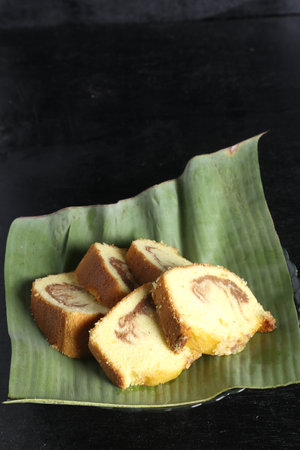cake in a banana leaf container on a black backgroundの写真素材