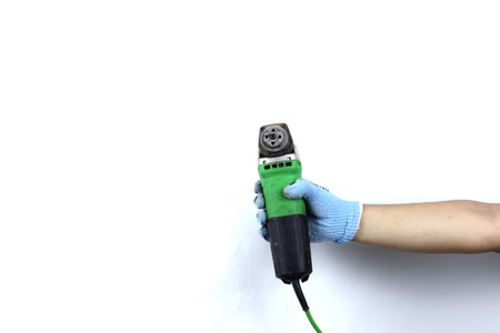 Gloved hand holding  angle grinder machine isolated on white backgroundの写真素材