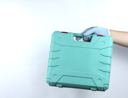 gloved hand holding toolbox isolated on white backgroundの写真素材