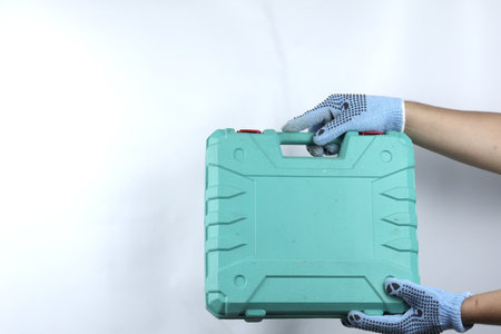 gloved hand holding toolbox isolated on white backgroundの写真素材