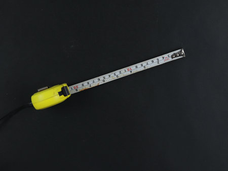 Yellow measuring tape isolated cut out on black backgroundの写真素材