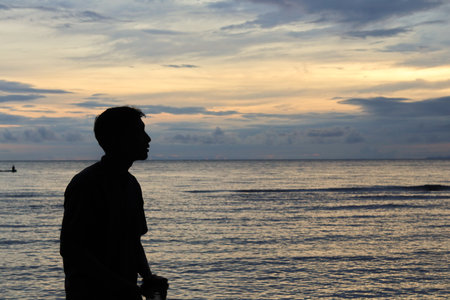 Silhouette of a man on the beach in the evening.の写真素材