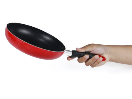 Hand holding a red frying pan isolated on white background with clipping pathの写真素材