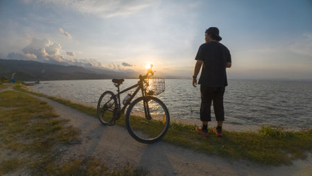 Cyclist on the shore of Lake Baikal at sunsetの写真素材